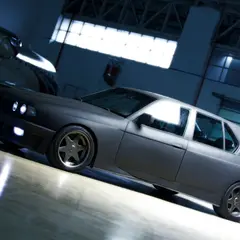 BMW M7 conversion — 7-series on E30 M3 body kit — side profile beside a military aircraft in a photo studio hangar